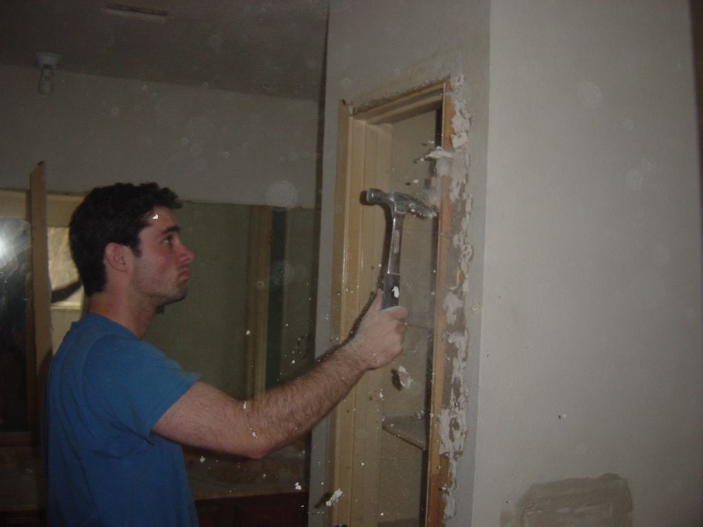 
Evanda ripping out drywall for insertion of the door

