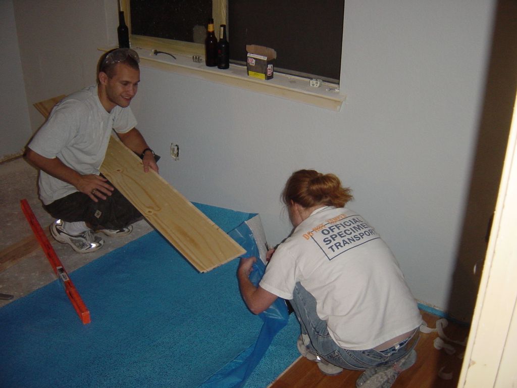 
Rick and Kara fixing the blue underlayment before the next row of flooring goes in.
