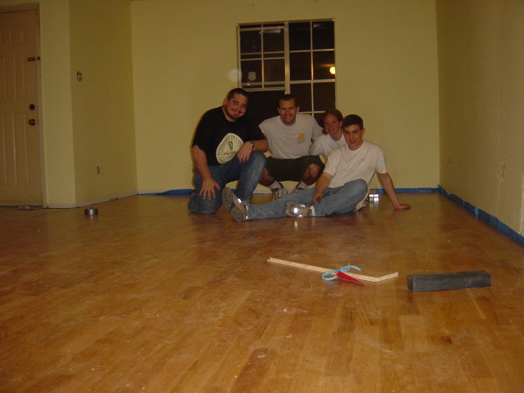 
Erich, RIck, Kara, and Matt.  The Living Room floor is done!  Also
shown are our friends, Mr. Shim and Mrs. Knocking Block.
