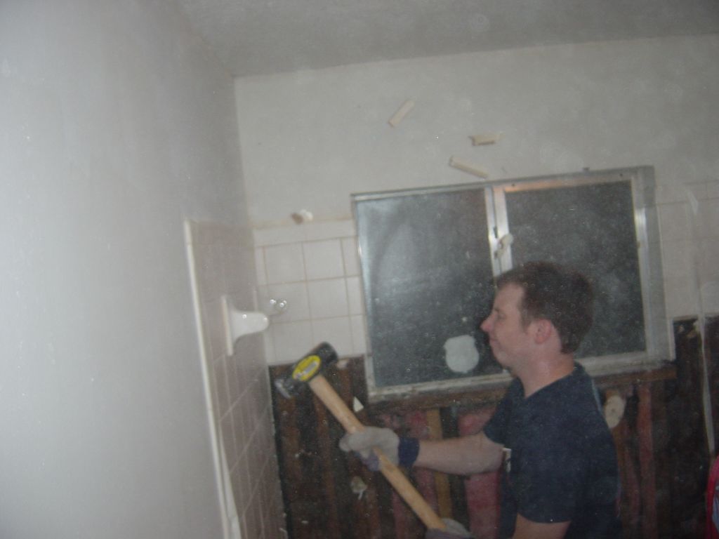 
David shatters the towel bar with the sledgehammer.  Note the pieces flying in the air above his head.  We tried to tell him to use safety glasses, but NOOOOOooooo... fortunately his eyes are closed.
