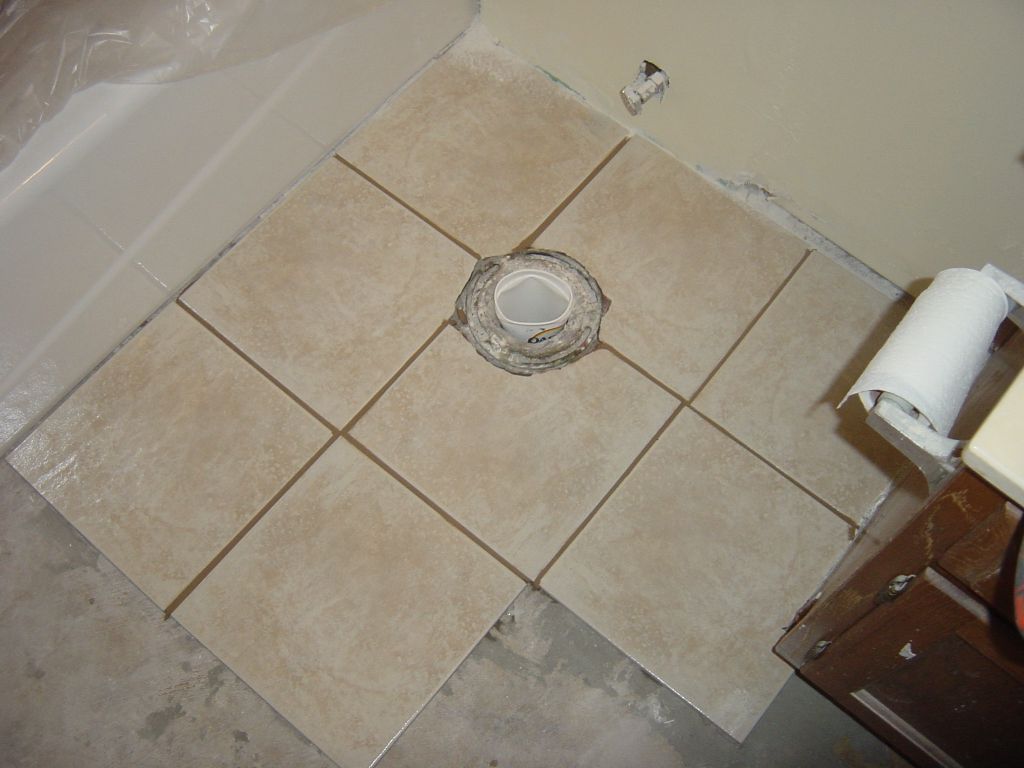 
The tile around where the toilet will go.  Note that this is Friday morning.
Matt moves in the next day.  I'm leaving town before he moves in.  So it's
really important to get the shower working and the toilet working.  So I 
just put tile around where the toilet goes.  The rest of the floor gets
tiled later.

